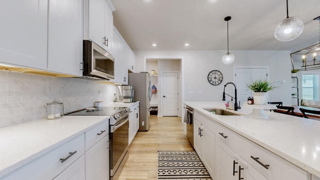 kitchen featuring a sink, decorative backsplash, white cabinets, and stainless steel appliances