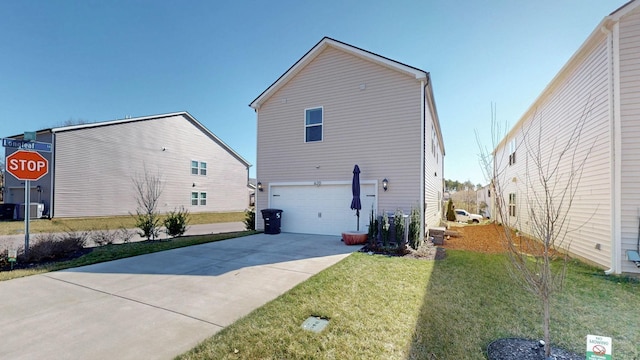 exterior space with concrete driveway, an attached garage, and a lawn