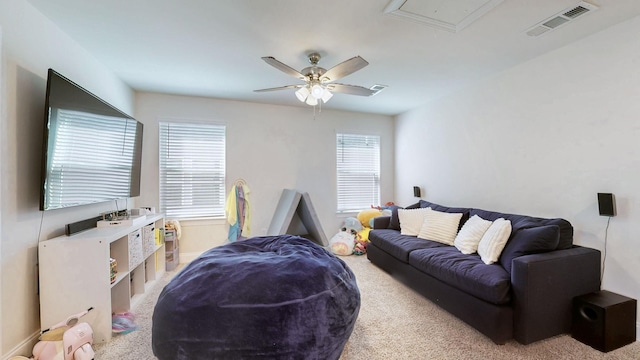 living room with visible vents, attic access, ceiling fan, and carpet floors