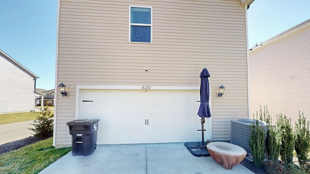 garage featuring central AC unit and driveway