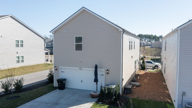 view of home's exterior featuring central air condition unit, an attached garage, and concrete driveway