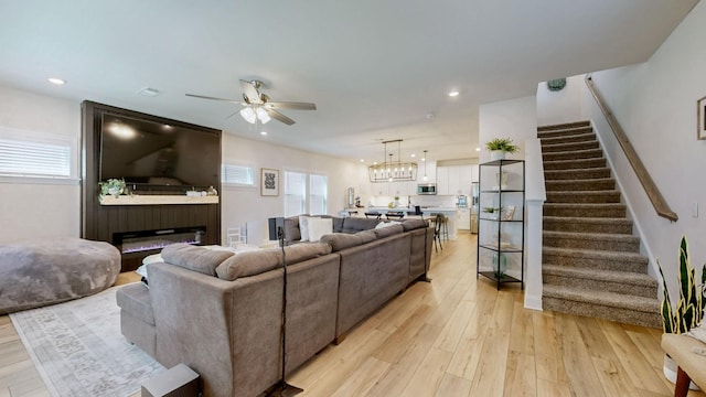 living room featuring recessed lighting, stairway, a healthy amount of sunlight, and light wood-style floors