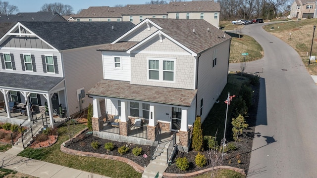 craftsman-style house featuring covered porch and a shingled roof