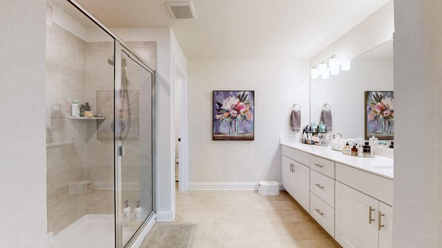 full bath with visible vents, baseboards, double vanity, a sink, and a shower stall