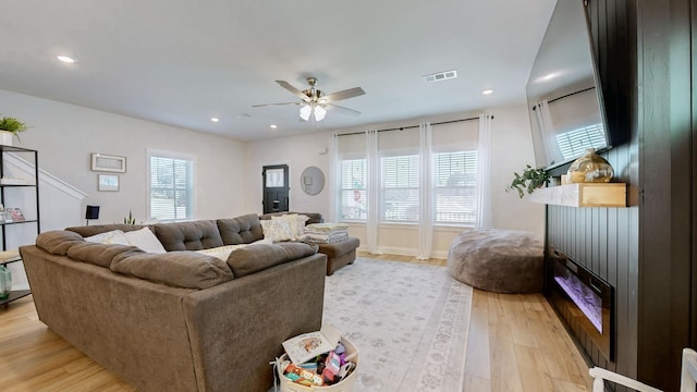 living area with a wealth of natural light, visible vents, light wood-style flooring, and recessed lighting