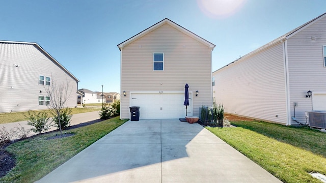 rear view of house featuring a garage, a lawn, central AC, and concrete driveway