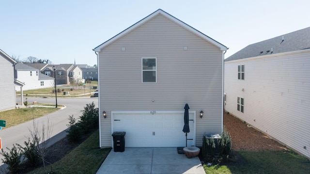 view of side of home featuring an attached garage and driveway