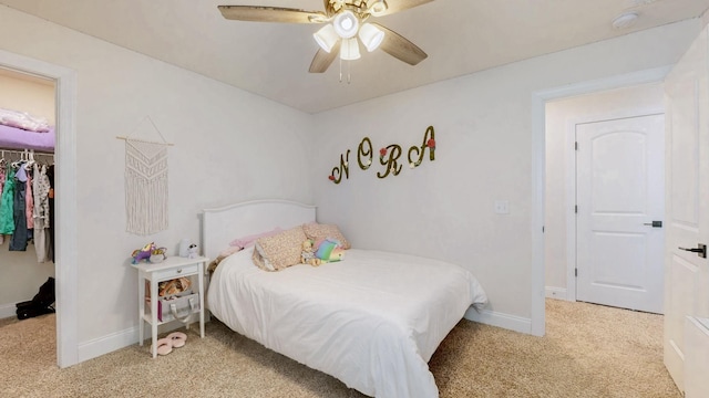 bedroom featuring a spacious closet, a closet, light carpet, and baseboards