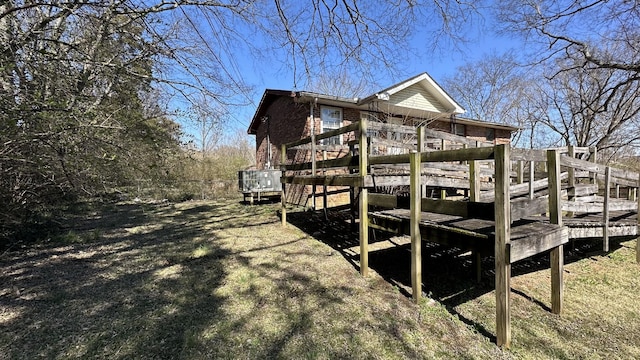 view of side of property with a deck and brick siding