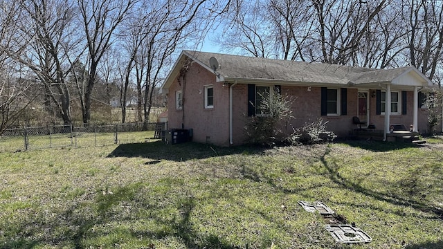 view of front of home featuring a front lawn, a gate, fence, crawl space, and brick siding