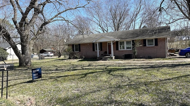 view of front of property featuring crawl space, brick siding, a front yard, and fence