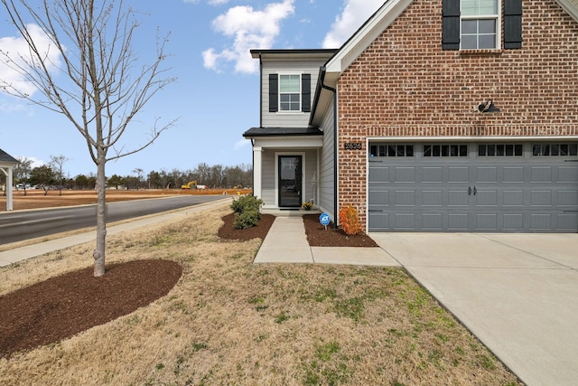 view of front of house featuring a garage, brick siding, and driveway