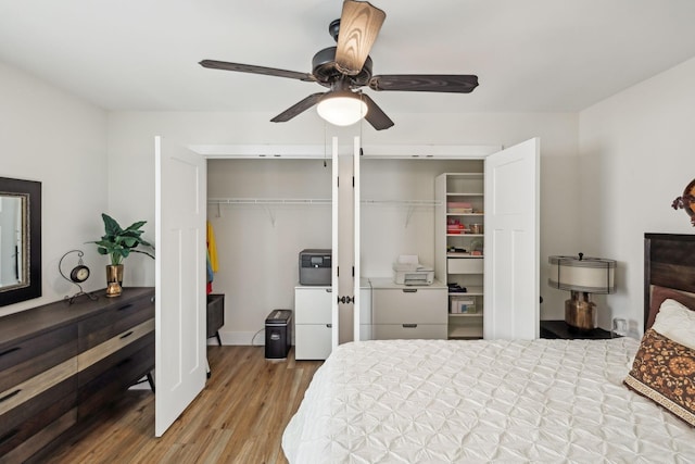 bedroom featuring two closets, a ceiling fan, and wood finished floors