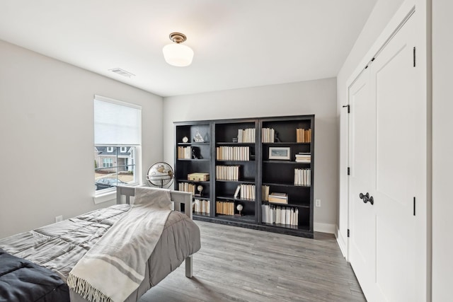 bedroom with visible vents and wood finished floors