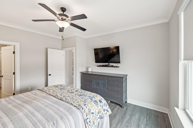 bedroom featuring baseboards, wood finished floors, ornamental molding, and a ceiling fan