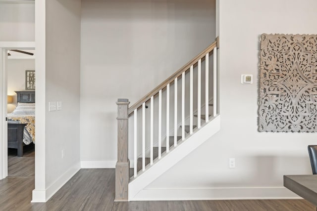 stairway with wood finished floors and baseboards