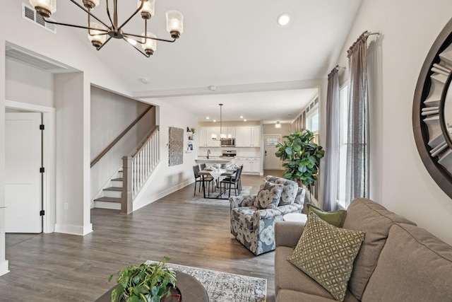 living area featuring stairway, visible vents, a chandelier, and dark wood-style floors