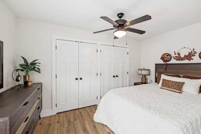 bedroom featuring multiple closets, a ceiling fan, and light wood finished floors