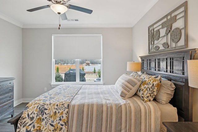 bedroom with visible vents, ornamental molding, a ceiling fan, wood finished floors, and baseboards