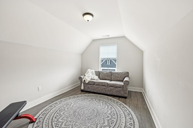 living area with lofted ceiling, wood finished floors, visible vents, and baseboards