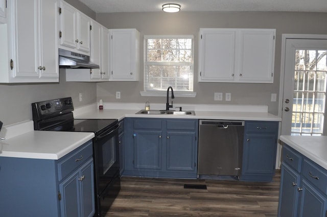 kitchen featuring under cabinet range hood, dishwashing machine, black / electric stove, and blue cabinets