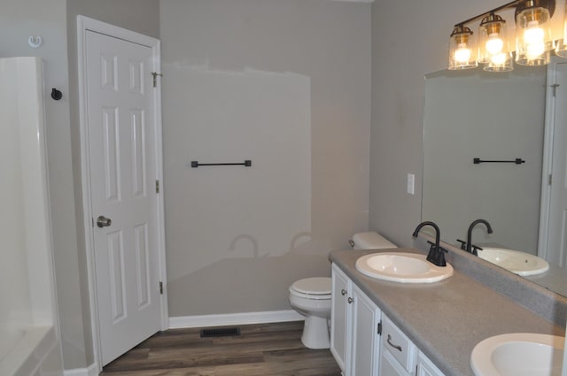 full bath with a sink, visible vents, and wood finished floors