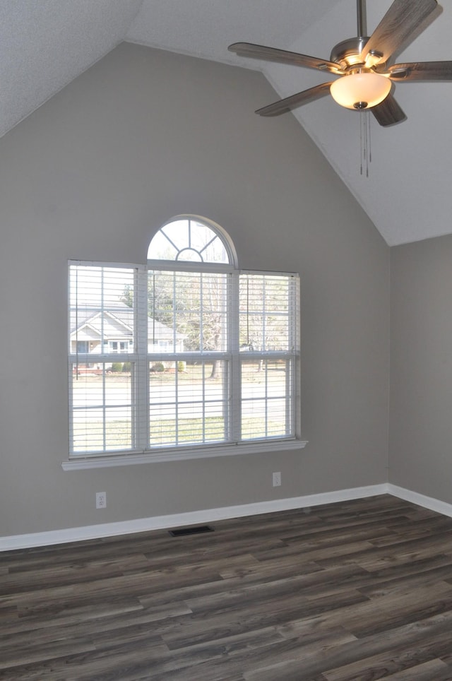 unfurnished room featuring visible vents, baseboards, dark wood finished floors, lofted ceiling, and a ceiling fan