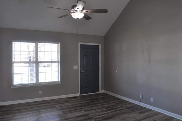 spare room featuring visible vents, ceiling fan, baseboards, dark wood finished floors, and vaulted ceiling