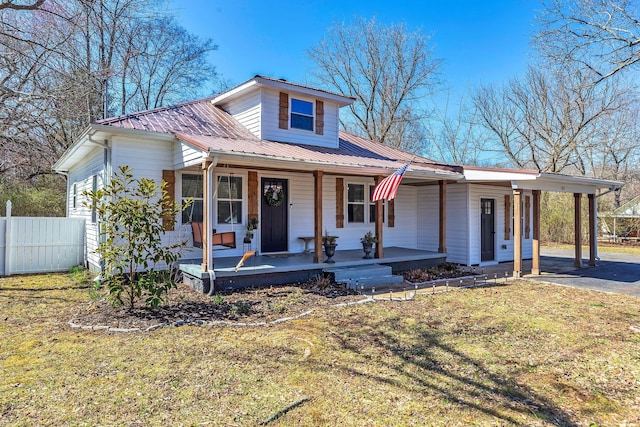 view of front of house with an attached carport, fence, covered porch, aphalt driveway, and metal roof