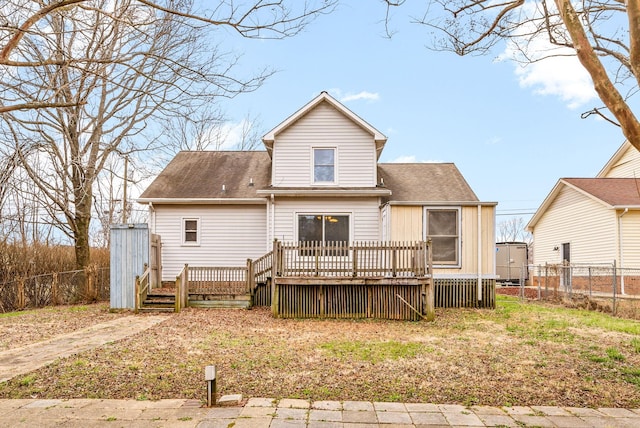 rear view of house with a wooden deck, a fenced backyard, and a shingled roof