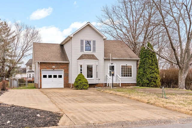 traditional-style home with a garage, roof with shingles, concrete driveway, and fence