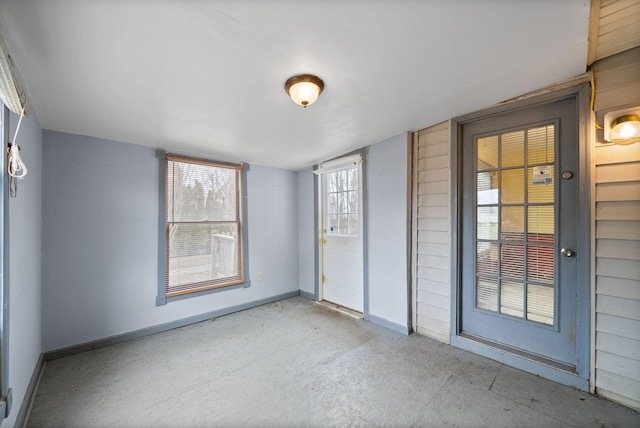 unfurnished room featuring baseboards and concrete floors