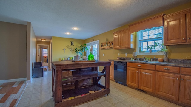 kitchen with a wealth of natural light, light floors, black dishwasher, and a sink