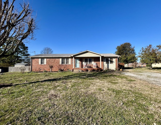 ranch-style house featuring a front lawn, a porch, fence, and brick siding