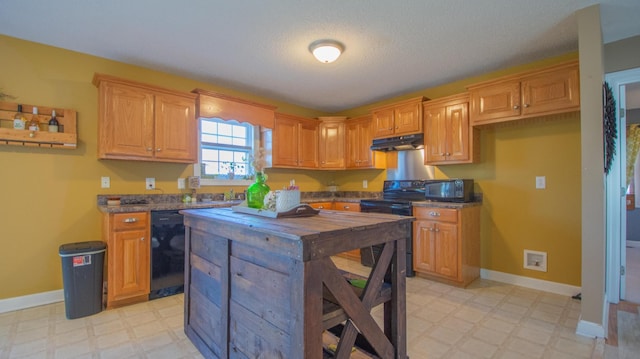 kitchen featuring under cabinet range hood, dark countertops, light floors, and black appliances