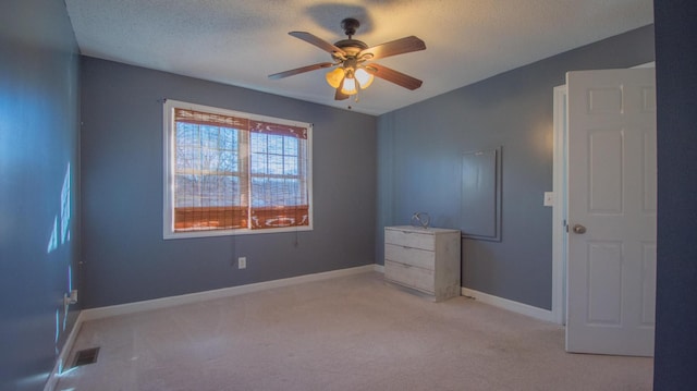 unfurnished bedroom with visible vents, baseboards, light colored carpet, and a textured ceiling