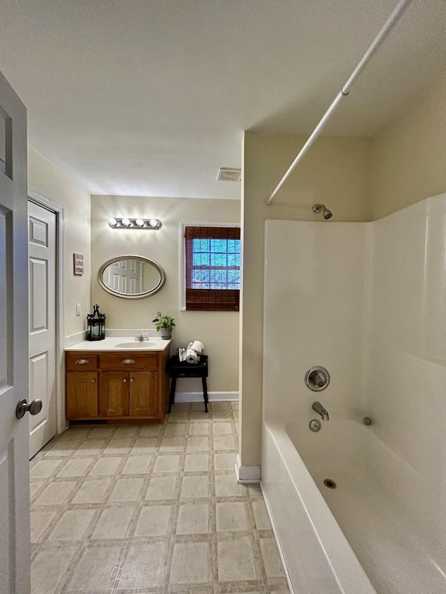 bathroom featuring vanity, baseboards, visible vents, shower / washtub combination, and tile patterned floors