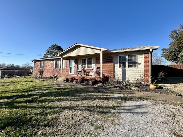 view of front of home featuring a front lawn, fence, and brick siding