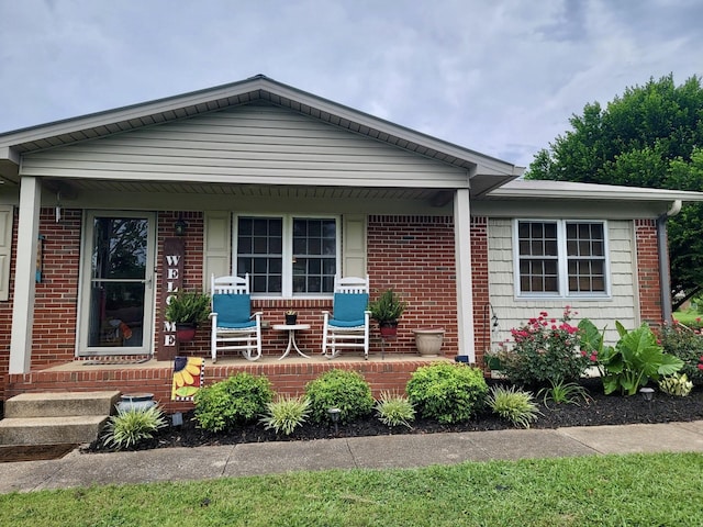 view of front of house with brick siding and a porch