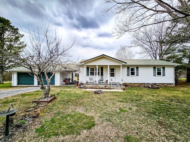 single story home featuring a front lawn, covered porch, driveway, and metal roof