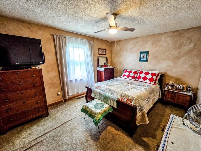 carpeted bedroom with a ceiling fan, visible vents, a textured wall, and a textured ceiling