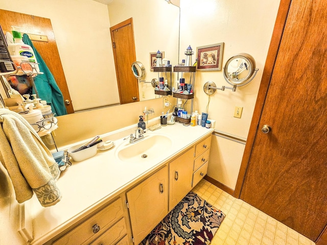 bathroom with vanity, tile patterned floors, and baseboards