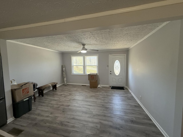 foyer featuring a textured ceiling, a ceiling fan, dark wood-style flooring, and ornamental molding