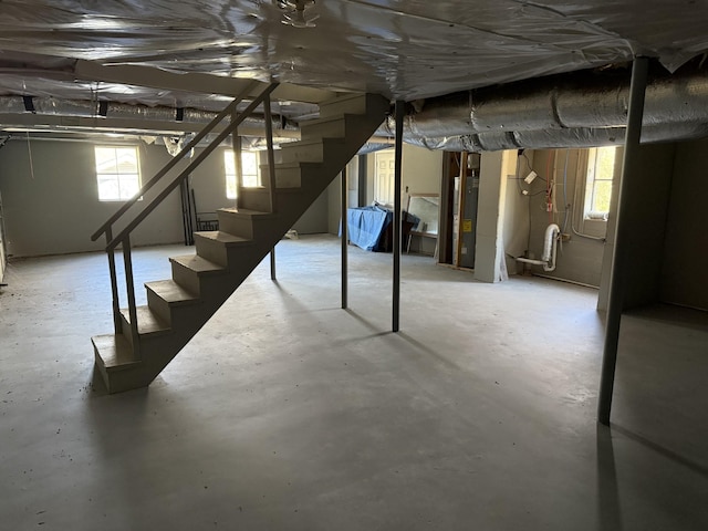 basement featuring stairs and water heater