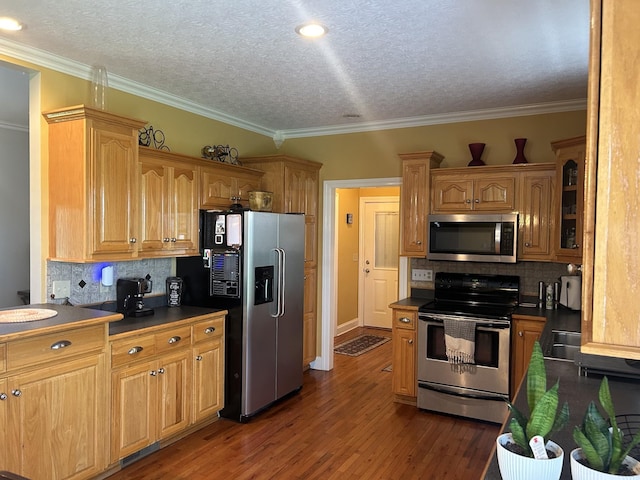 kitchen with stainless steel appliances, dark countertops, and dark wood-style flooring