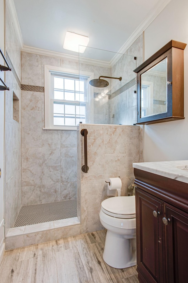 full bath featuring toilet, ornamental molding, a walk in shower, wood finished floors, and vanity