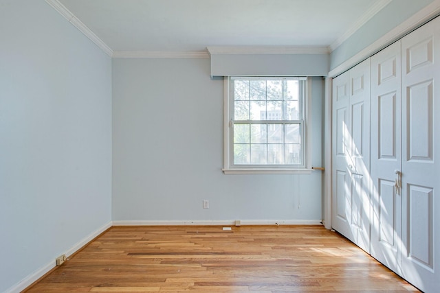 unfurnished bedroom with a closet, baseboards, light wood-style flooring, and ornamental molding