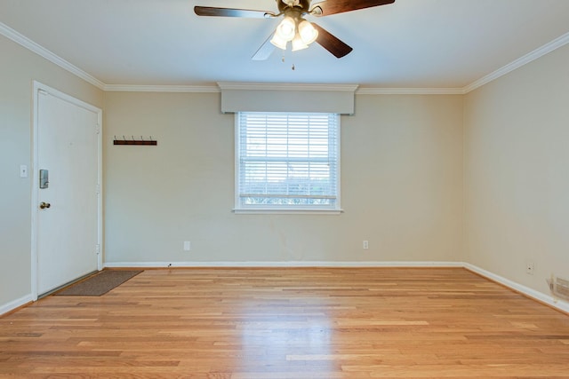 spare room with crown molding, light wood-style flooring, and baseboards