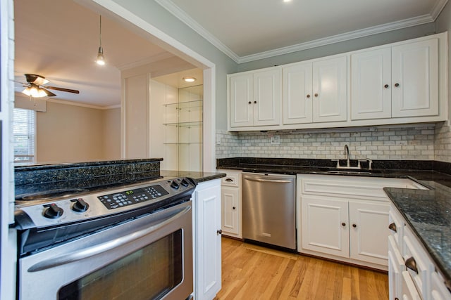 kitchen featuring light wood-type flooring, stainless steel appliances, white cabinets, crown molding, and decorative backsplash