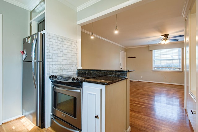 kitchen featuring ornamental molding, a ceiling fan, backsplash, wood finished floors, and stainless steel appliances